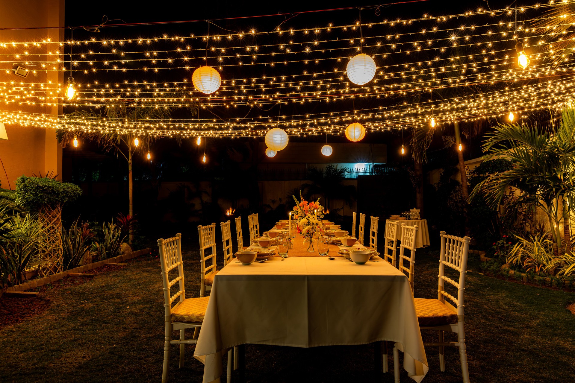 Summer winter candle light dinner party theme with fine dinning arrangements fairy lights and latrines in garden!